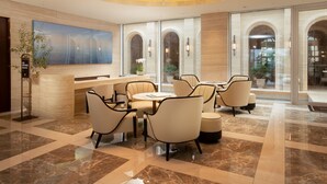 A modern lobby with a reception desk, seating area, and a large chandelier. - The Siena PRIMO (Seogwipo)