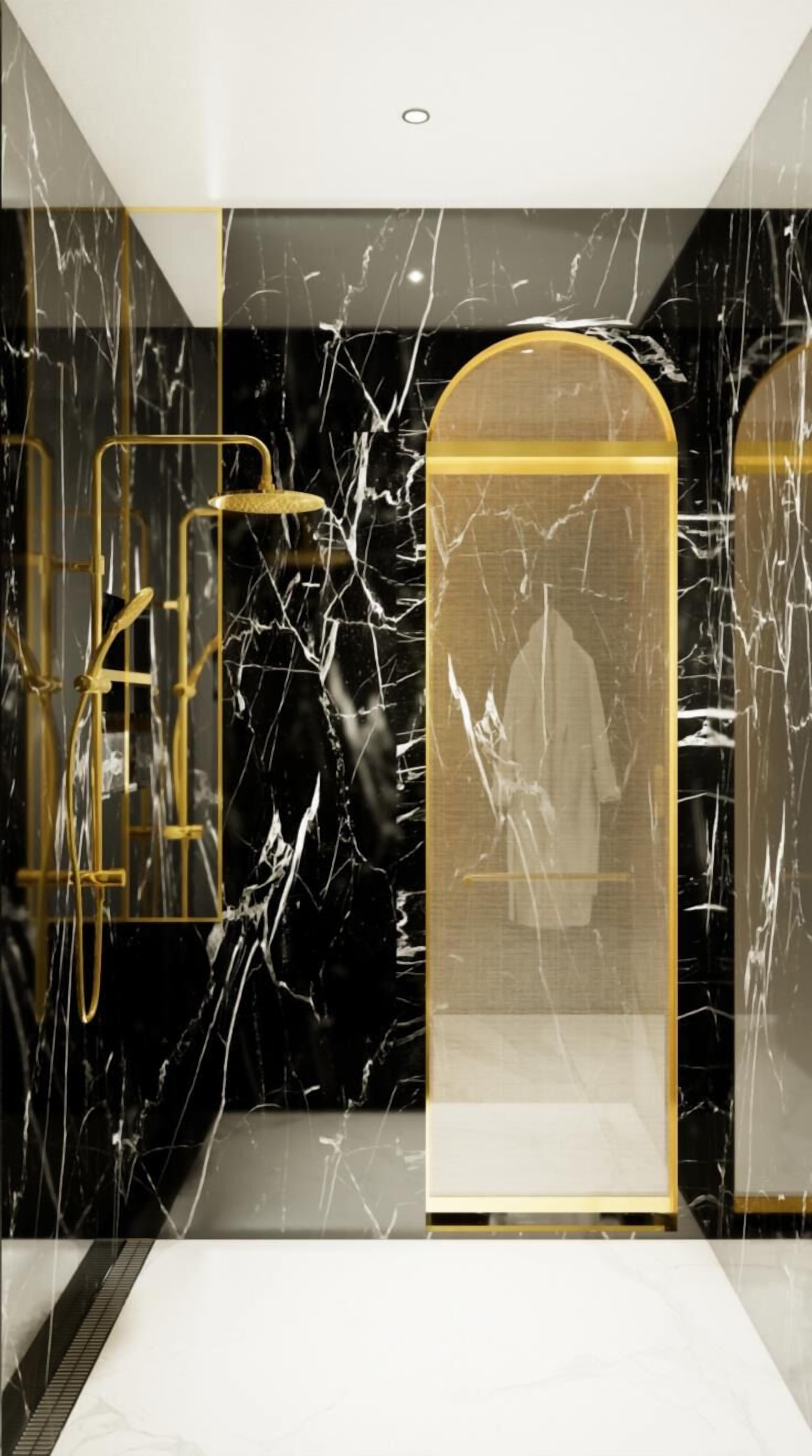 A modern elevator interior with marble walls and gold accents, featuring a glass enclosure with a person inside.