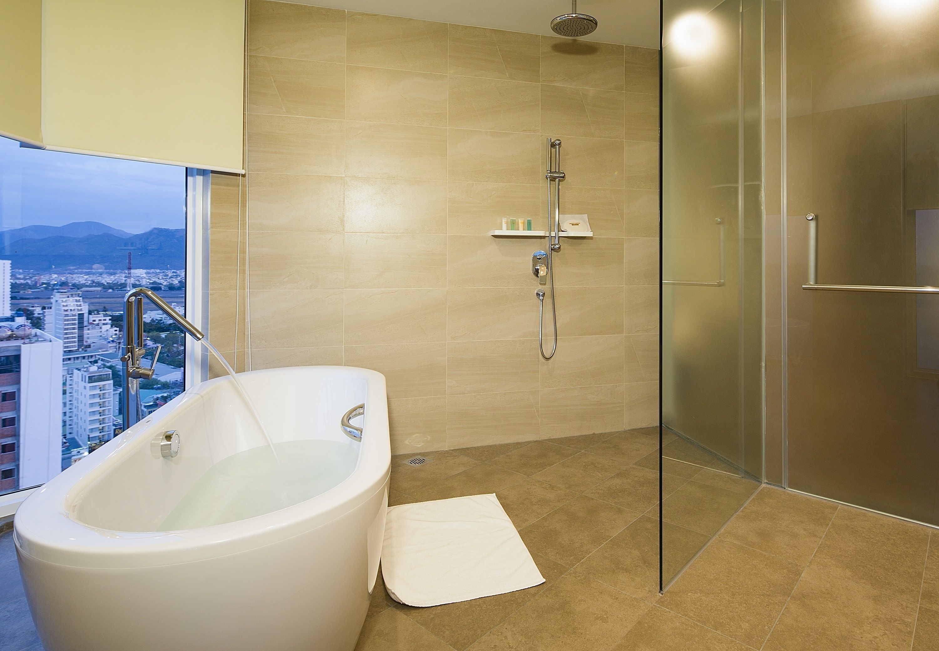 Une salle de bain moderne équipée d’une baignoire, d’une douche et d’un espace de douche séparé par des parois en verre.