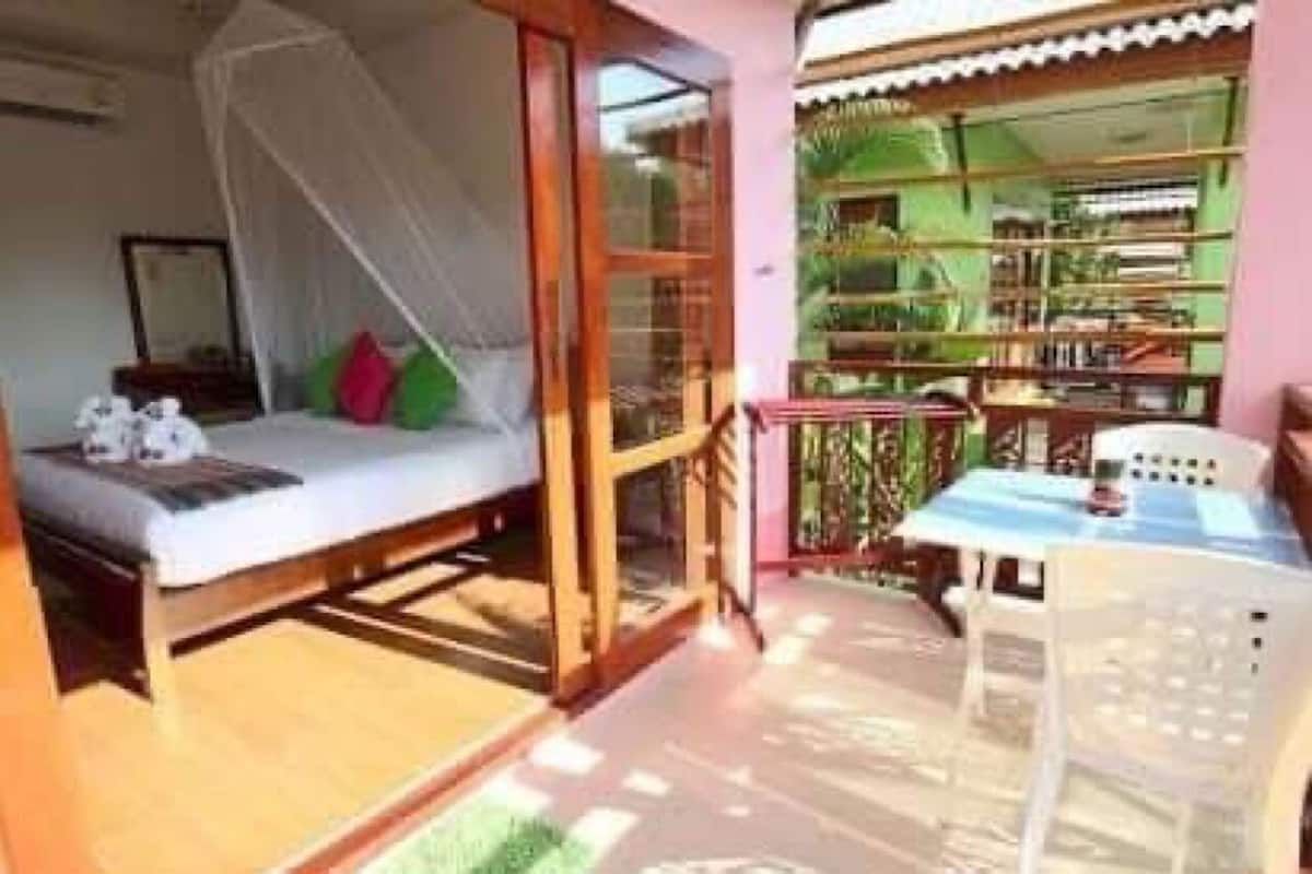 A room with a bed, a table, and a chair.