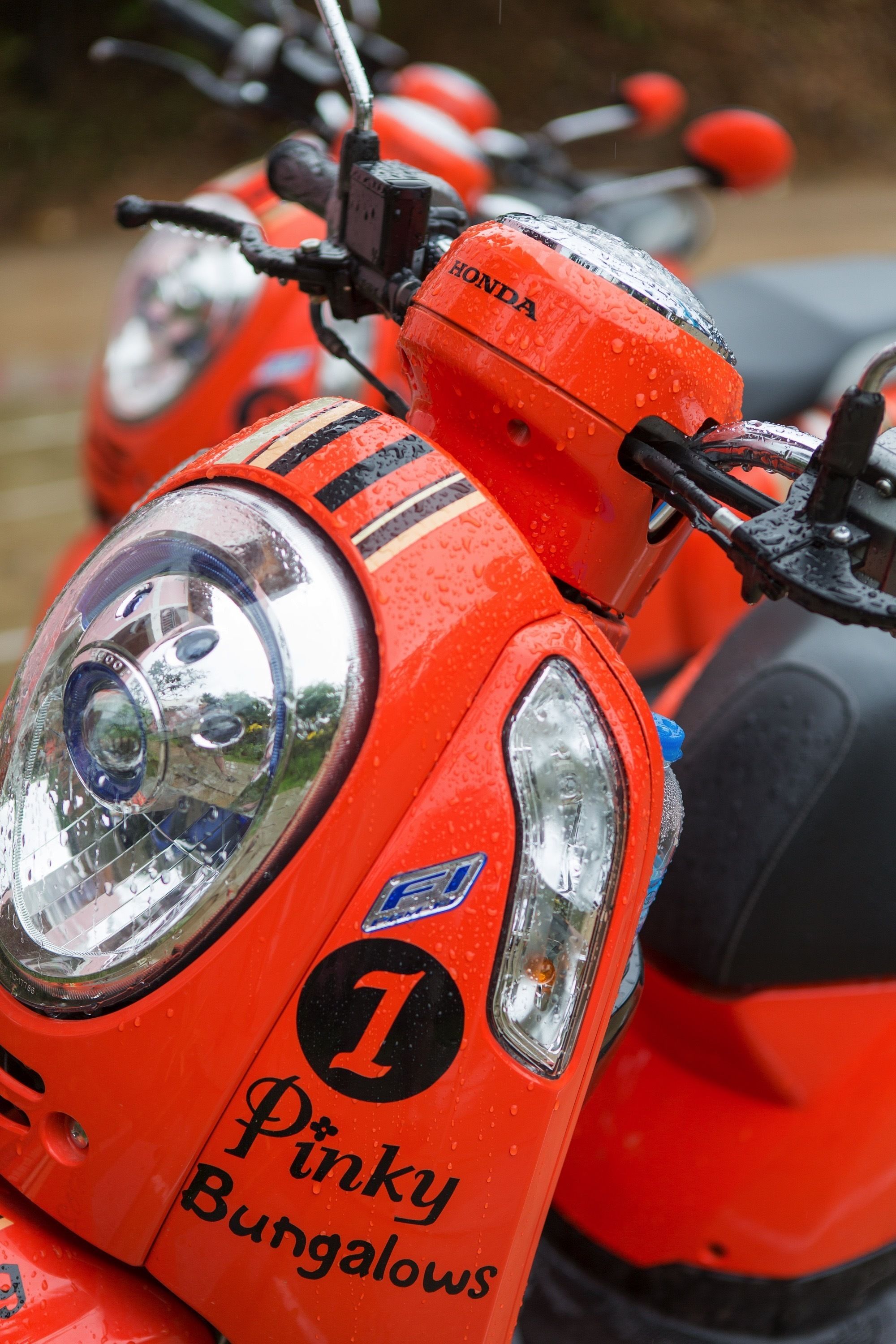 Una motocicleta roja con el número 1 y el texto 'Pinky Bungalows'.
