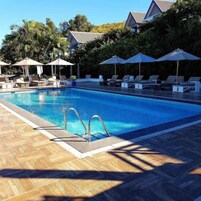 Una piscina al aire libre, sillones reclinables de piscina