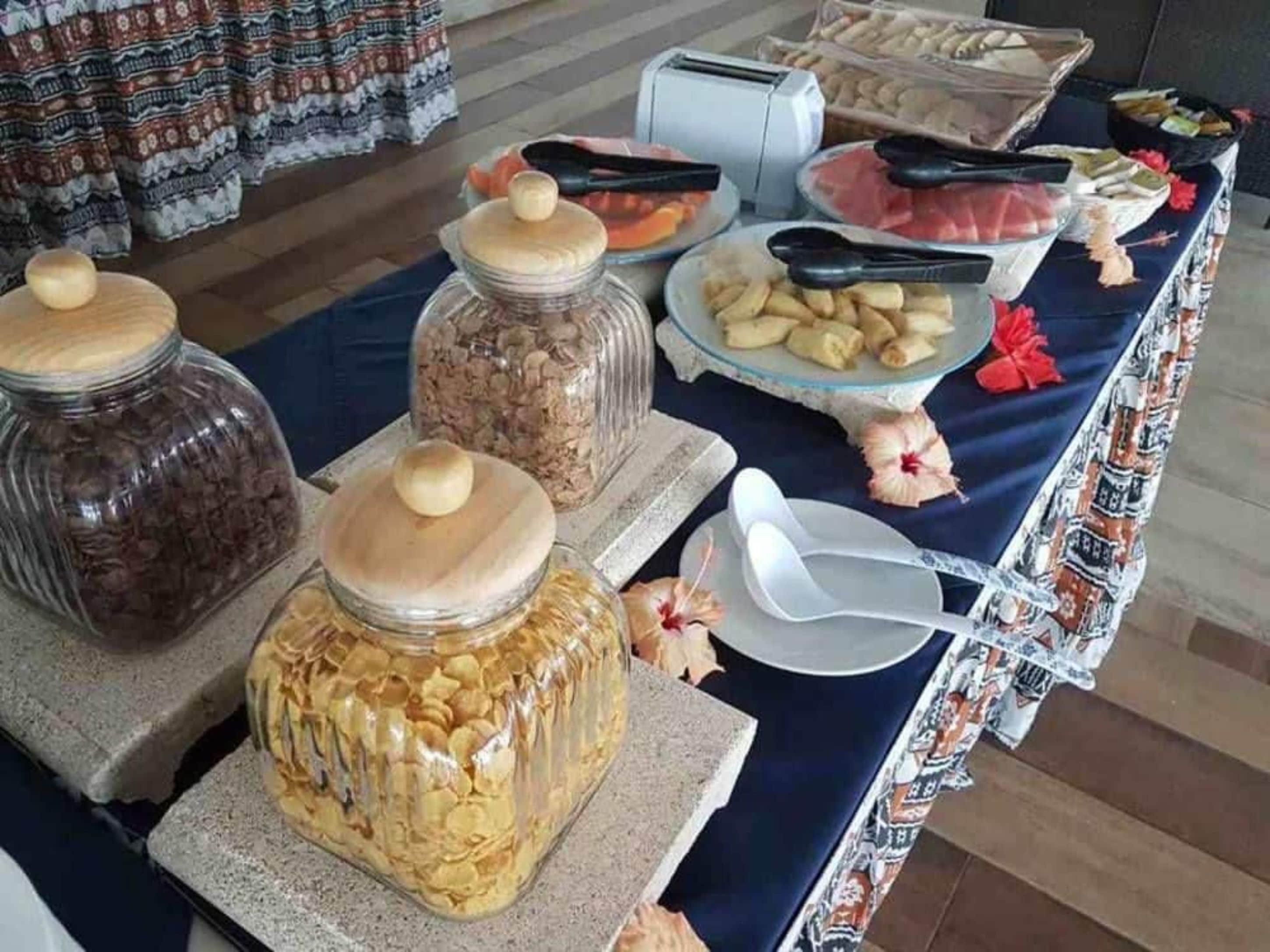 A buffet table with various food items and utensils.