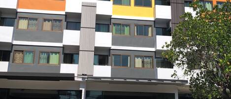 A multi-story building with a modern architectural design, featuring a mix of white, yellow, and grey colors.