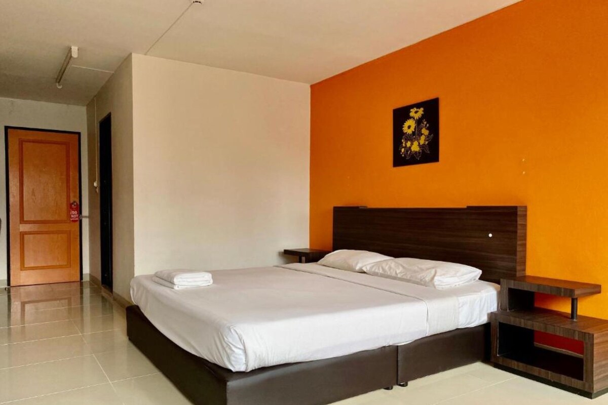 Una camera da letto moderna con un letto grande, un comodino e un'opera d'arte appesa al muro.