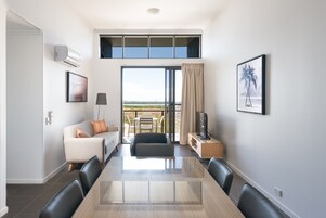 Una sala de estar moderna con una mesa de comedor, sofá y televisor.