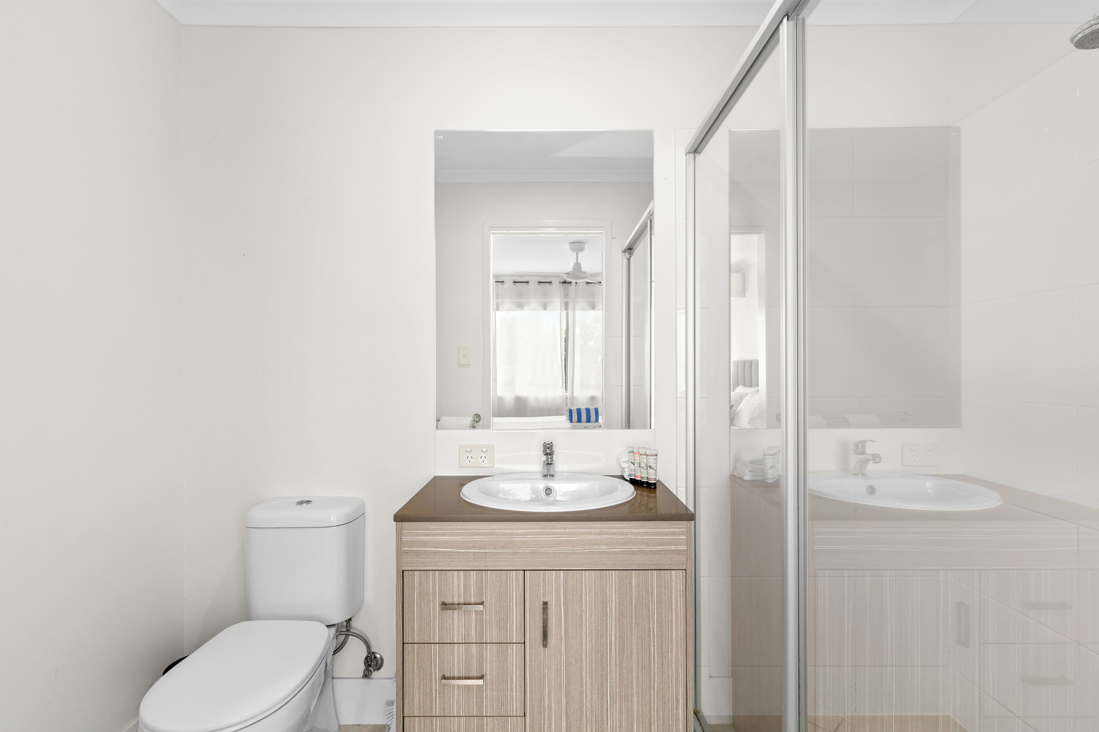 Une salle de bain moderne équipée de toilettes, d’un lavabo et d’un espace douche.