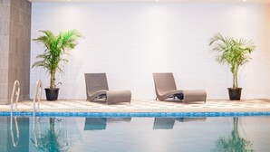 Ein Poolbereich mit zwei Liegestühlen und zwei Blumentöpfen.