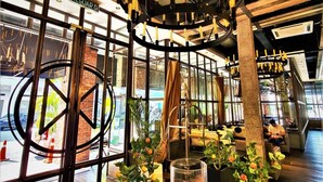 A modern interior with a circular chandelier, large windows, and potted plants. - M Boutique Station 18 (Ipoh)