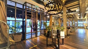 A modern interior with a glass table, wooden flooring, and a view of the street outside. - M Boutique Station 18 (Ipoh)