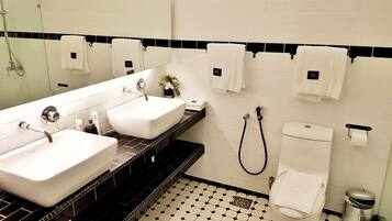 A bathroom with two sinks, a toilet, and a shower.