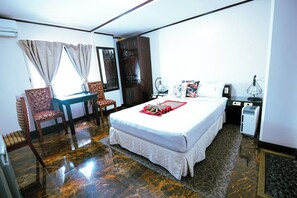 A hotel room with a bed, a desk, a chair, and a wardrobe. - Hotel Asia (Cebu City)