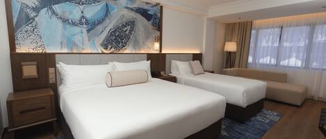 A hotel room with two beds, a large abstract painting, a nightstand, a lamp, and a view of the outdoors.