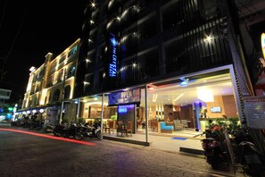 A hotel with a glass facade, outdoor seating area, and a sign indicating 'OPEN SEP 22'. - The Crystal Beach Hotel (Patong)