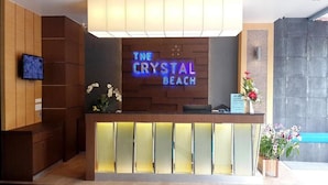 A reception desk with a neon sign reading "The Crystal Beach". - The Crystal Beach Hotel (Patong)