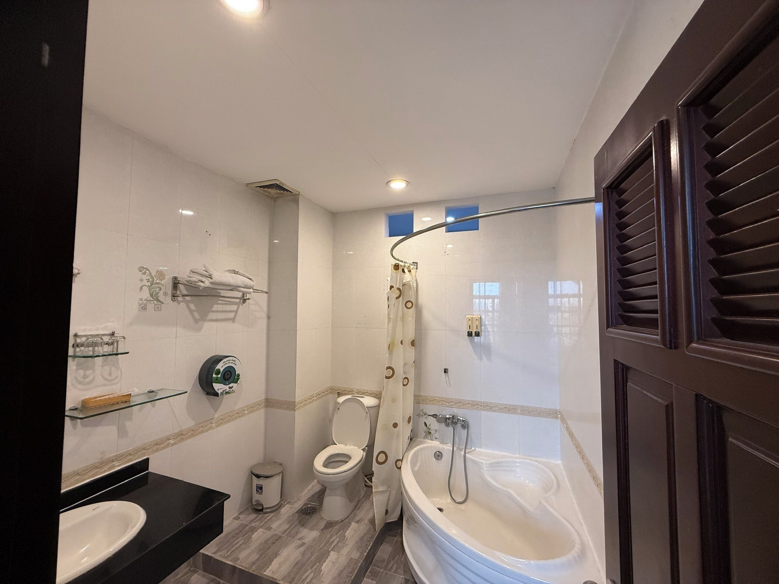 A bathroom with a toilet, a sink, a bathtub, and a shower curtain.