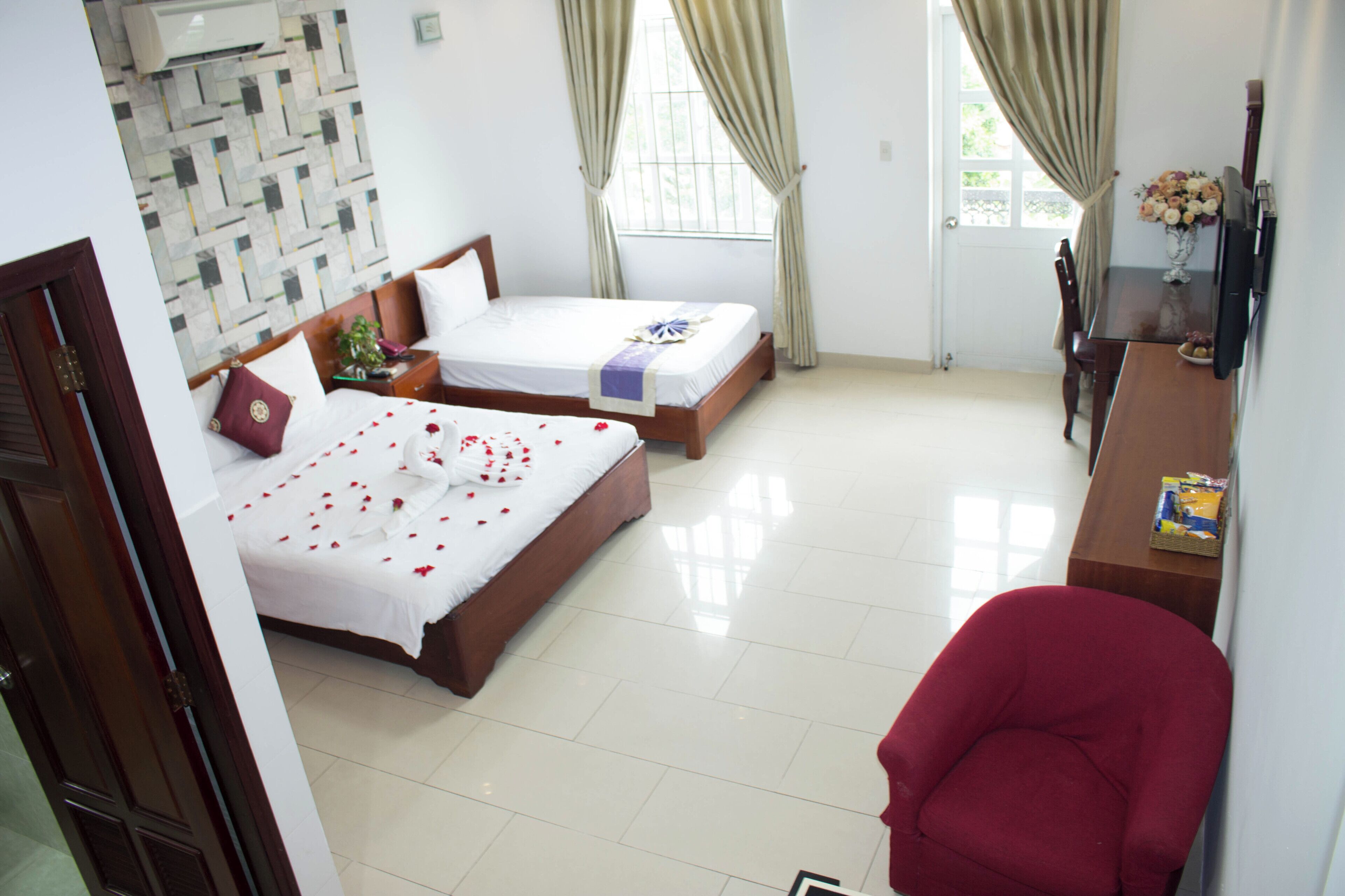 Deluxe Triple Room | Minibar, in-room safe, desk, blackout drapes