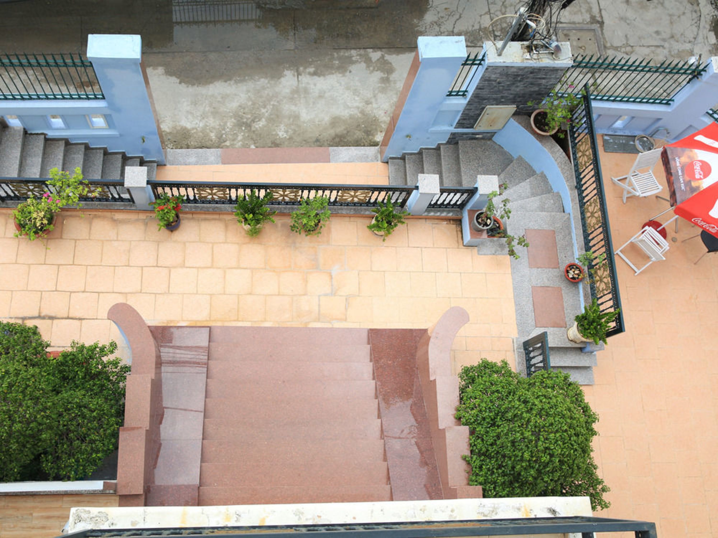 A staircase leading to a terrace with outdoor seating and potted plants.