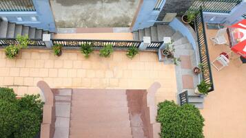A staircase leading to a terrace with outdoor seating and potted plants.
