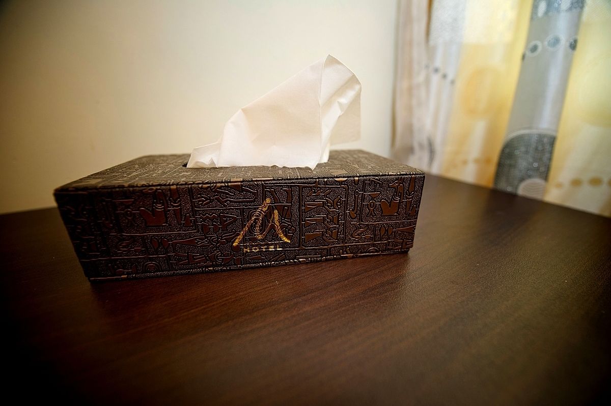 Una caja de pañuelos con diseños elaborados sobre una superficie de madera.