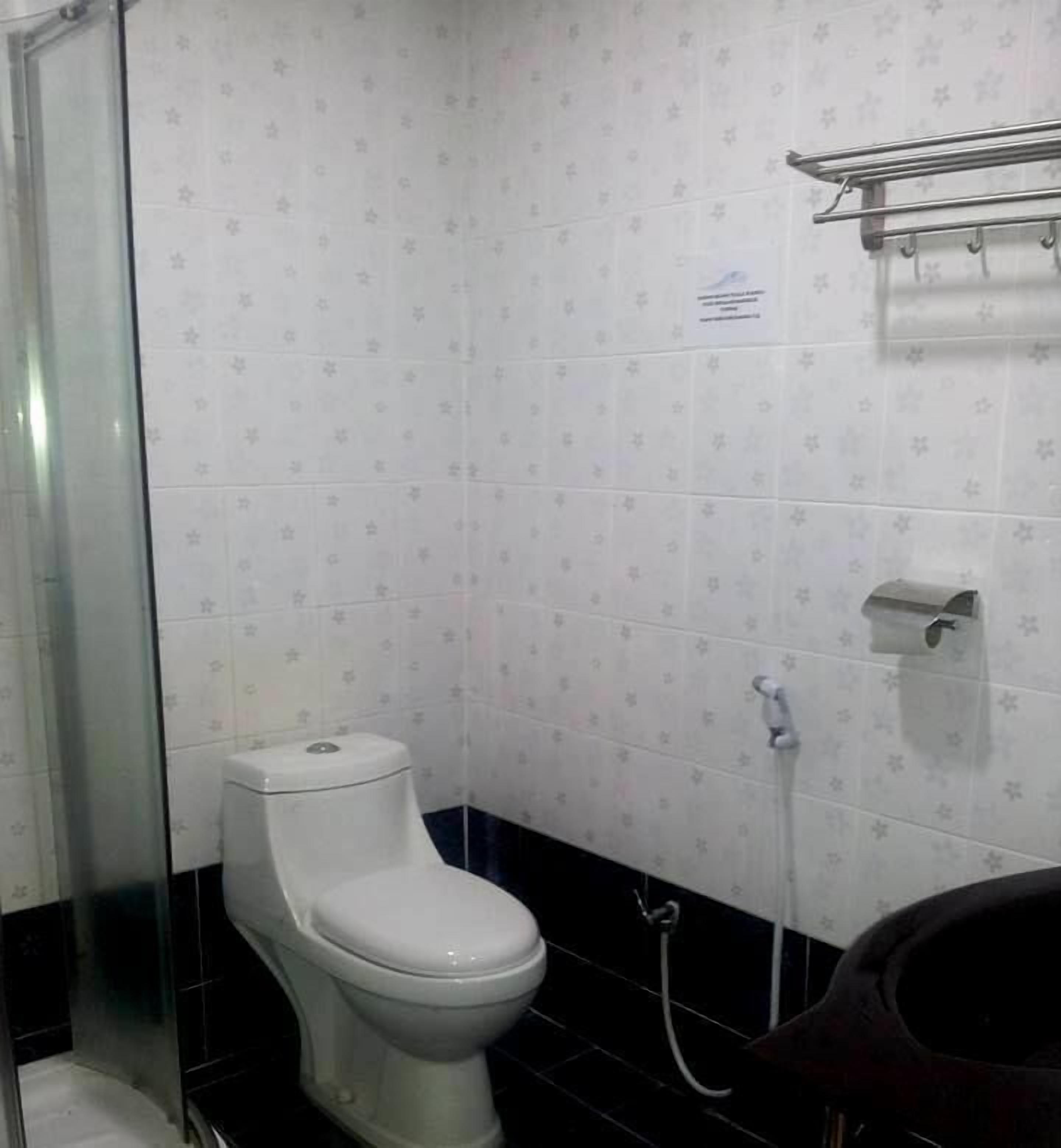 A small bathroom with a toilet, a shower, and a sink.