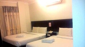 A hotel room with two single beds, a nightstand with a phone, and a window with curtains. - Hotel Bintang Indah (Kota Bharu)