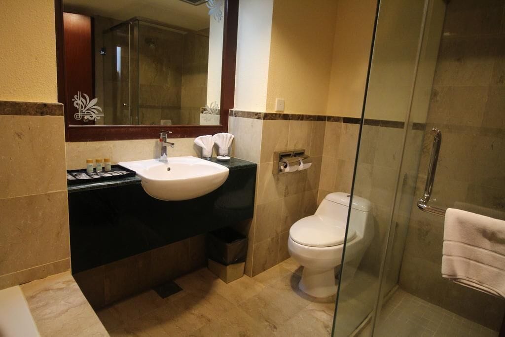 A bathroom with a sink, toilet, and glass shower enclosure.