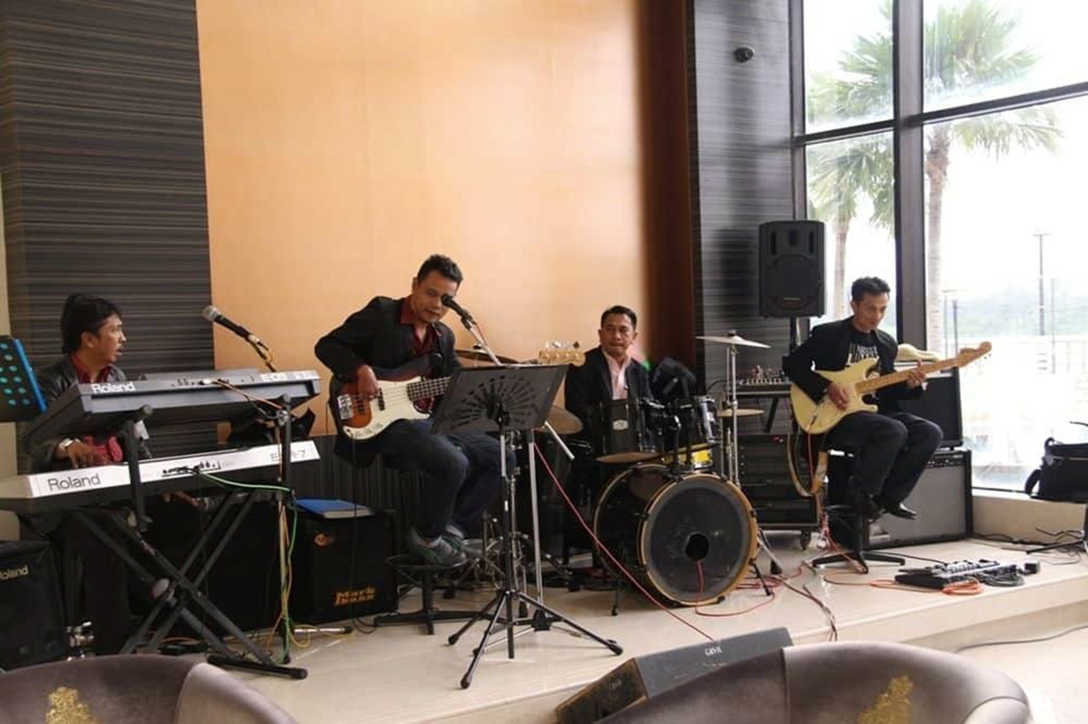 Una banda tocando en un escenario, con instrumentos musicales y un teclado.