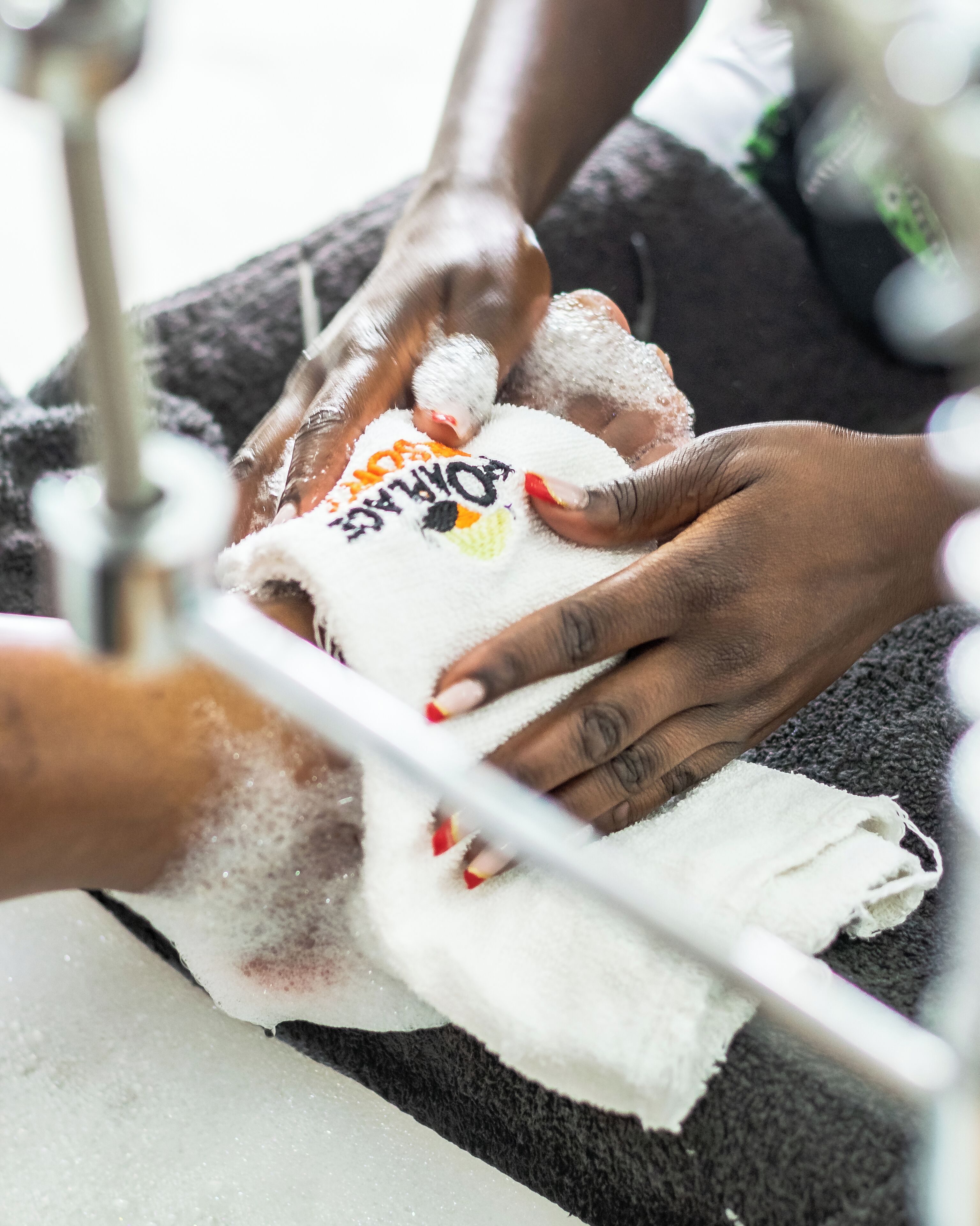 A close-up of hands receiving a manicure.