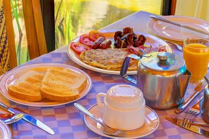 A breakfast table with plates of toast, eggs, sausages, and tomatoes, a jug of milk, and a pot of coffee. - Poa Place Resort & Hotel - Where Nature Meets Comfort Eldoret (Eldoret)