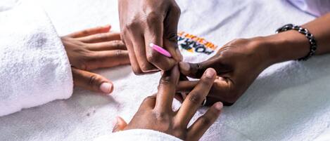A close-up of hands receiving a manicure.