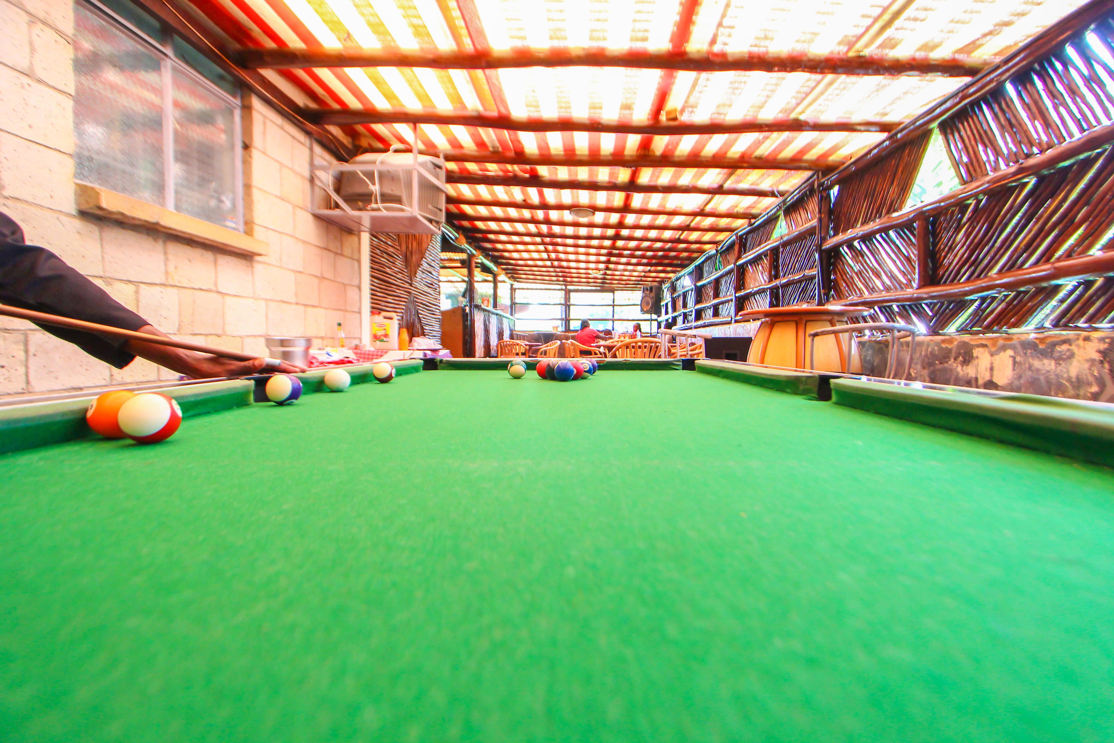 A pool table with balls, a wooden table, and a green felt surface.