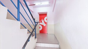 A staircase with blue handrails and a red door with a white arrow. - Hotel O Destiny Riverside Hotel (Kota Bharu)