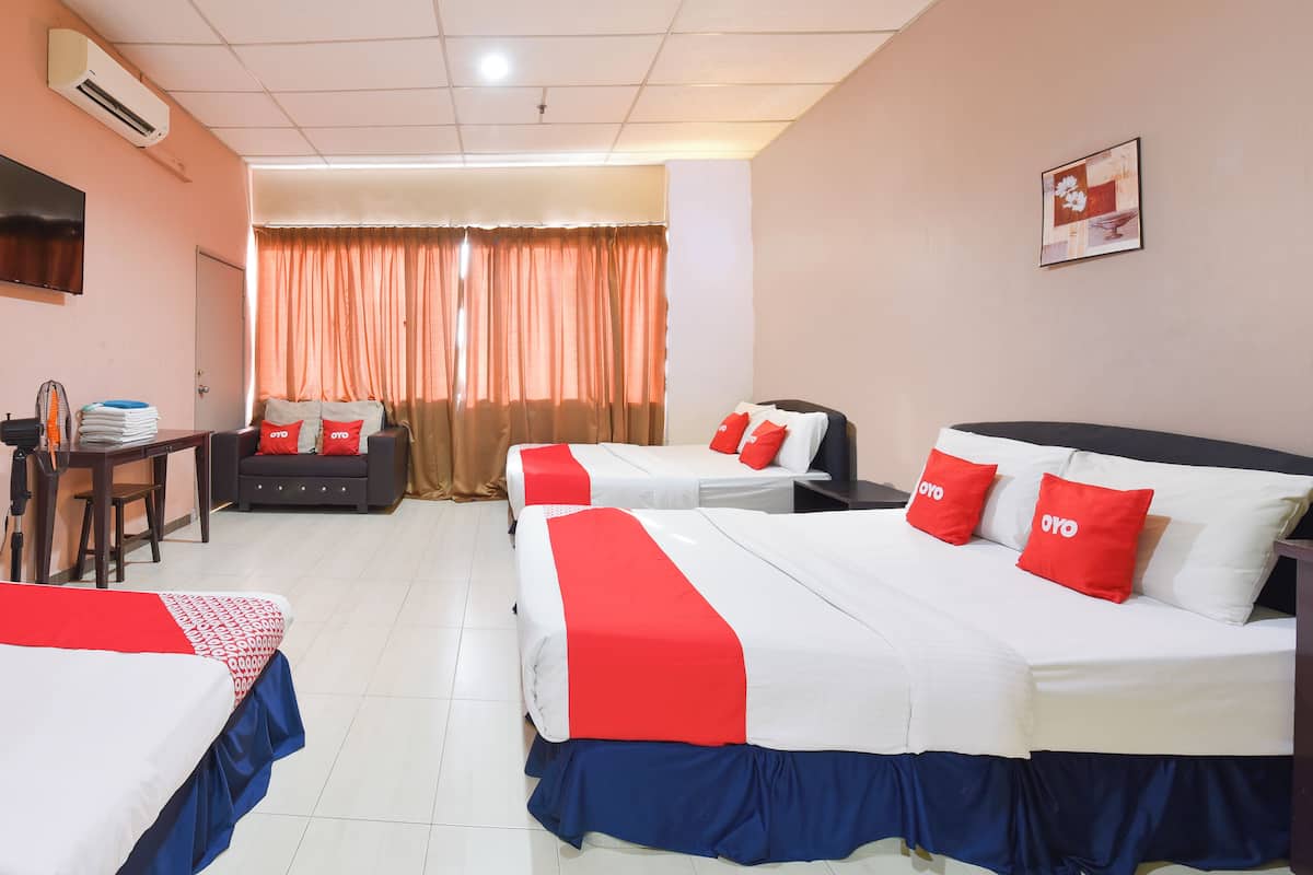 A hotel room with two beds, a desk, and a chair.