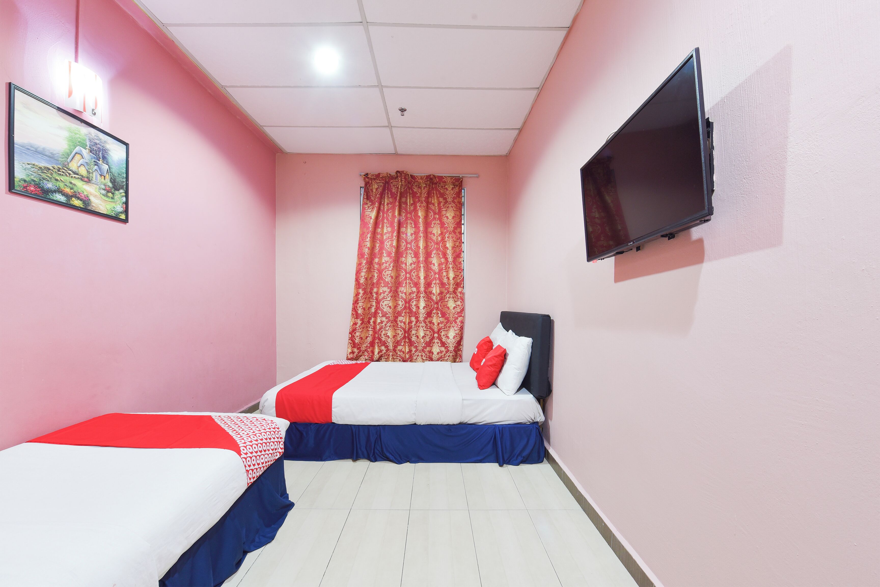 Une chambre avec deux lits, un téléviseur fixé au mur et un tableau accroché au mur.