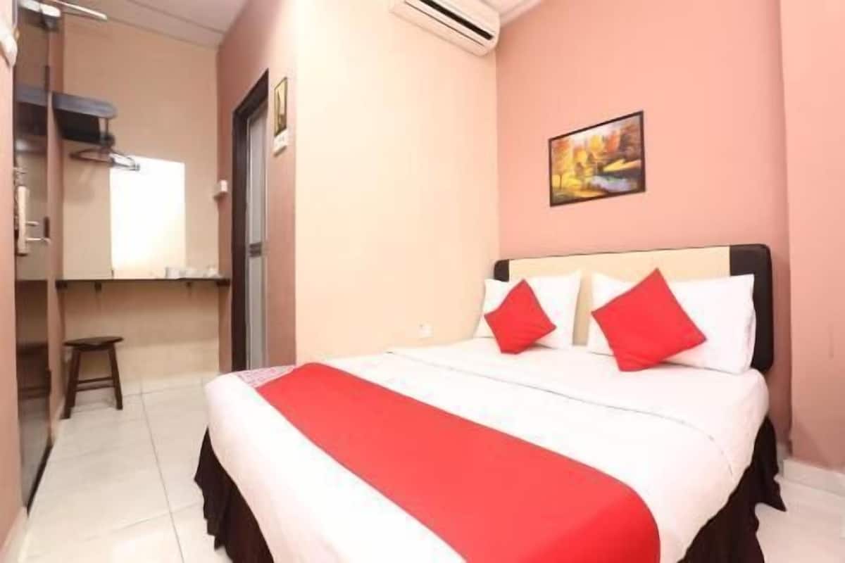 A hotel room with a bed, a desk, and a chair.