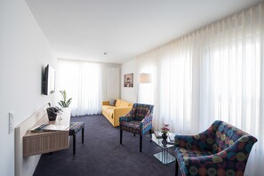 Junior Suite | Living room | 49-inch flat-screen TV with satellite channels, TV - Book Hotel Leipzig (Leipzig)