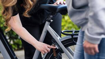 A person adjusting a stationary bike.