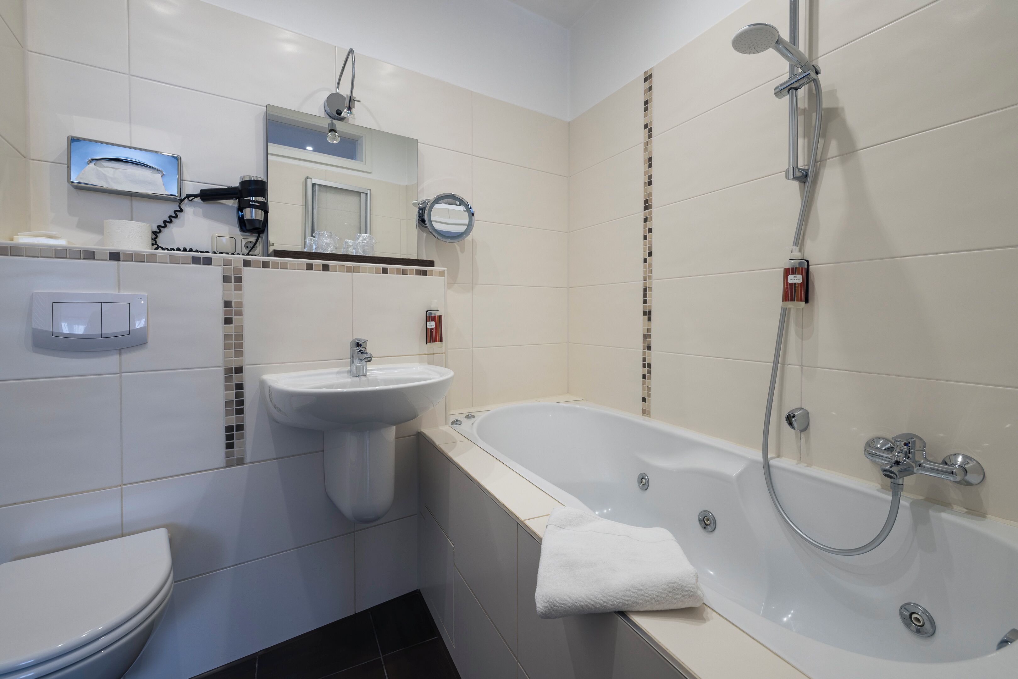Une salle de bain moderne équipée de toilettes, d’un lavabo et d’une baignoire.