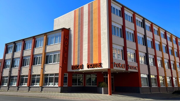 A hotel with a modern design, featuring a prominent 'hotel home' sign on the facade. - home Hotel (Wilhelmshaven)
