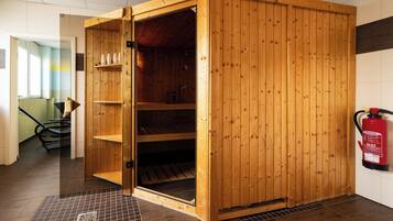 Eine Sauna mit Holzfassade, Glastür und gefliestem Boden.