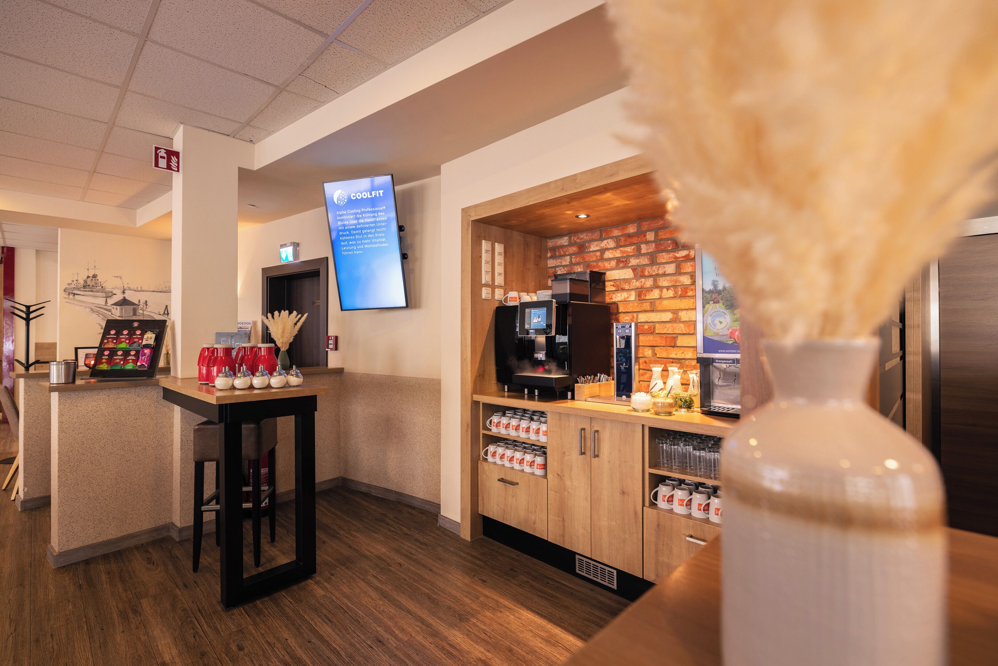 Een hotelbar met een koffieapparaat, een menubord en een bakstenen muur.