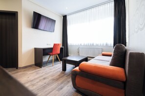 Suite – junior, 1 soverom, gårdsplassområde | Oppholdsområde | En 32-tommers Flatskjerm-TV med Parabol-TV samt TV