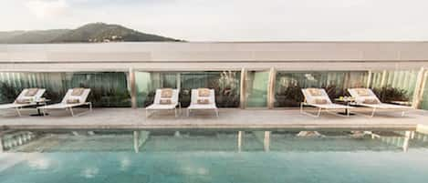 Piscine extérieure, parasols de plage, chaises longues