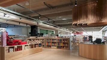 Una librería amplia con pasillos espaciosos, estanterías de madera y un mostrador central.