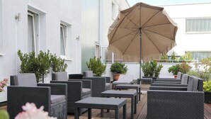 An outdoor seating area with wicker furniture and a large umbrella.