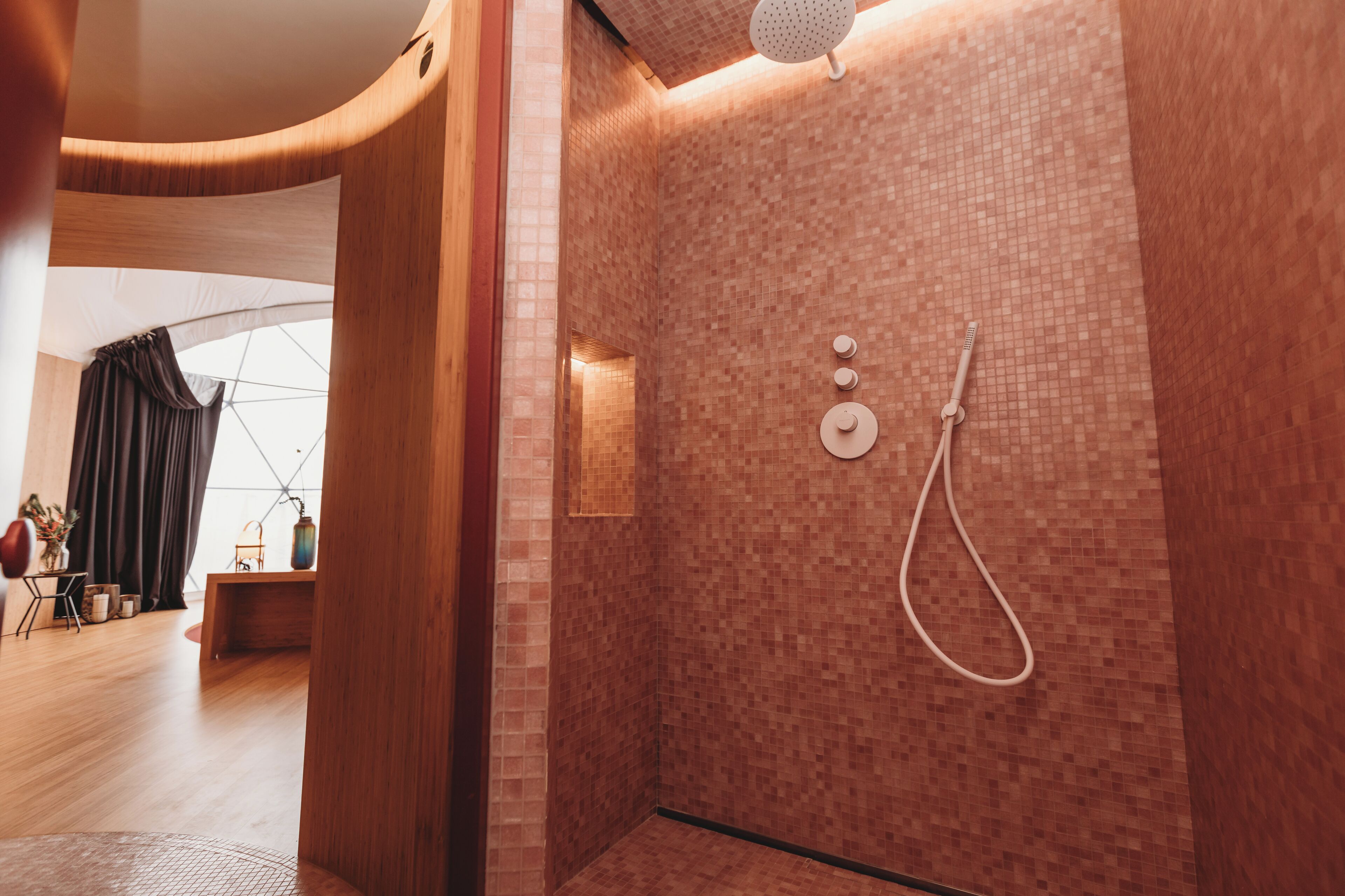 Une salle de bain moderne avec une douche, des murs carrelés et un plancher en bois.