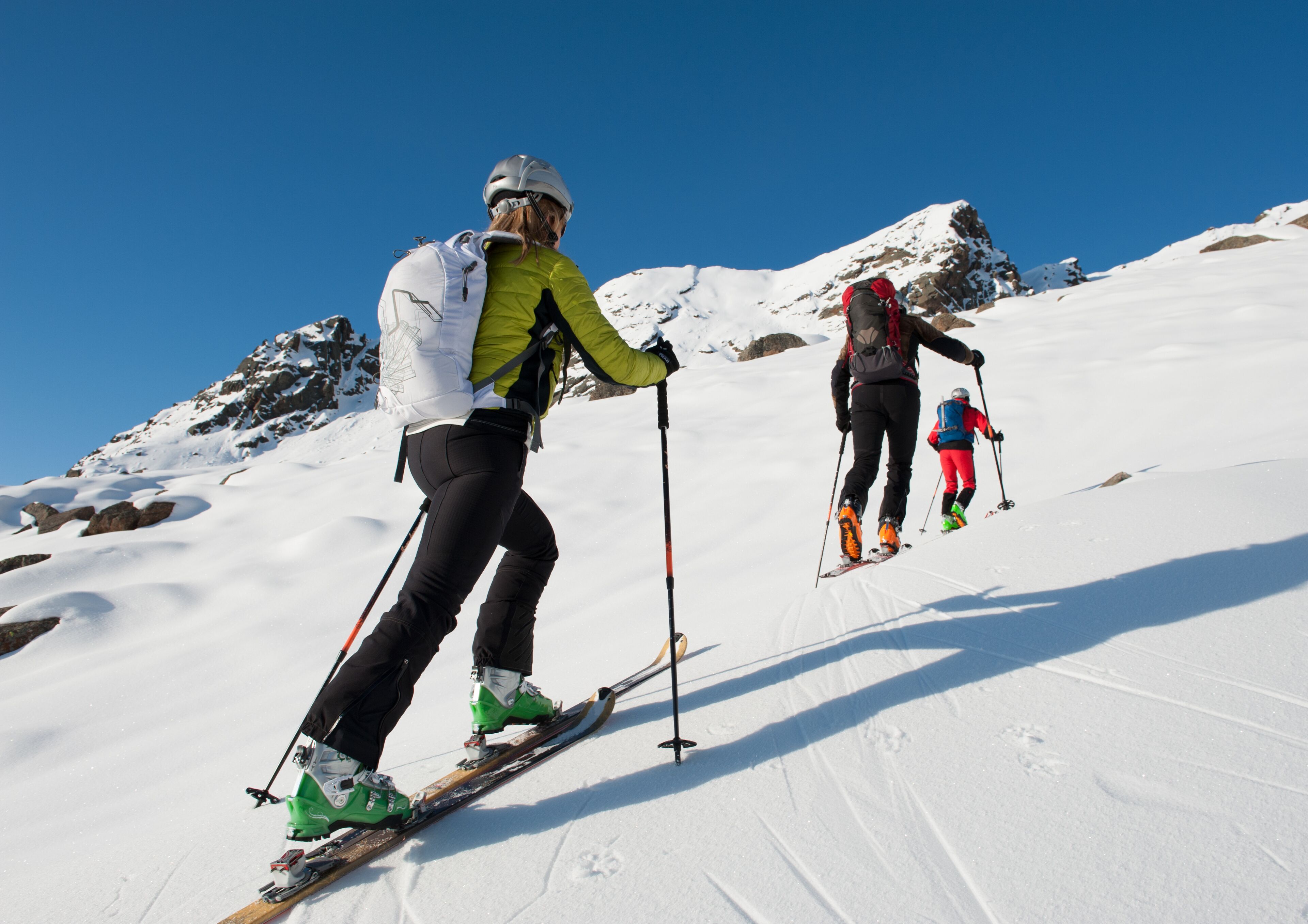 A snowy mountain slope with skiers.