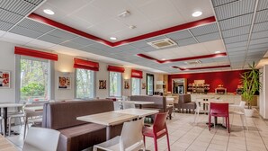 Un restaurant moderne avec des banquettes, des tables et un espace bar.