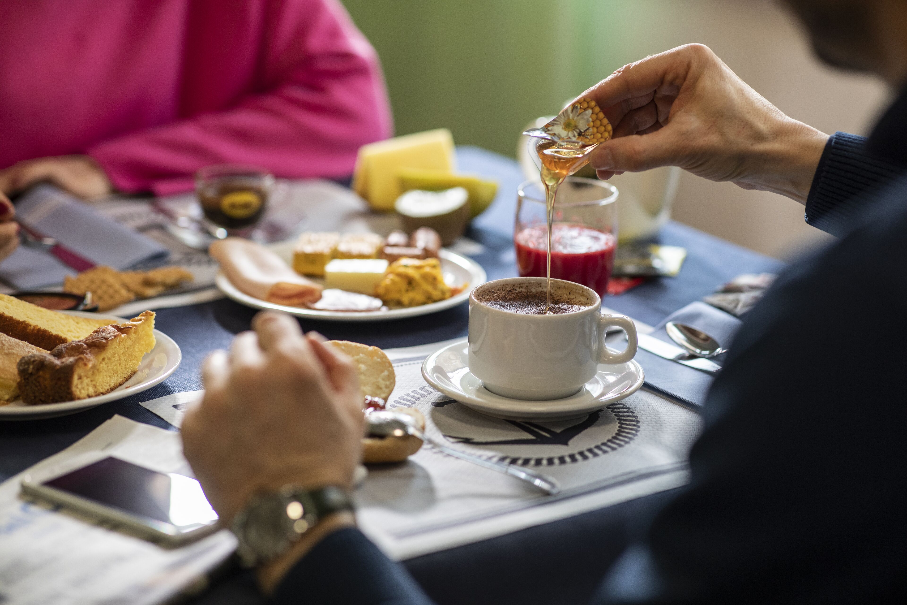 Una mesa de comedor con diversos alimentos y una taza de café.